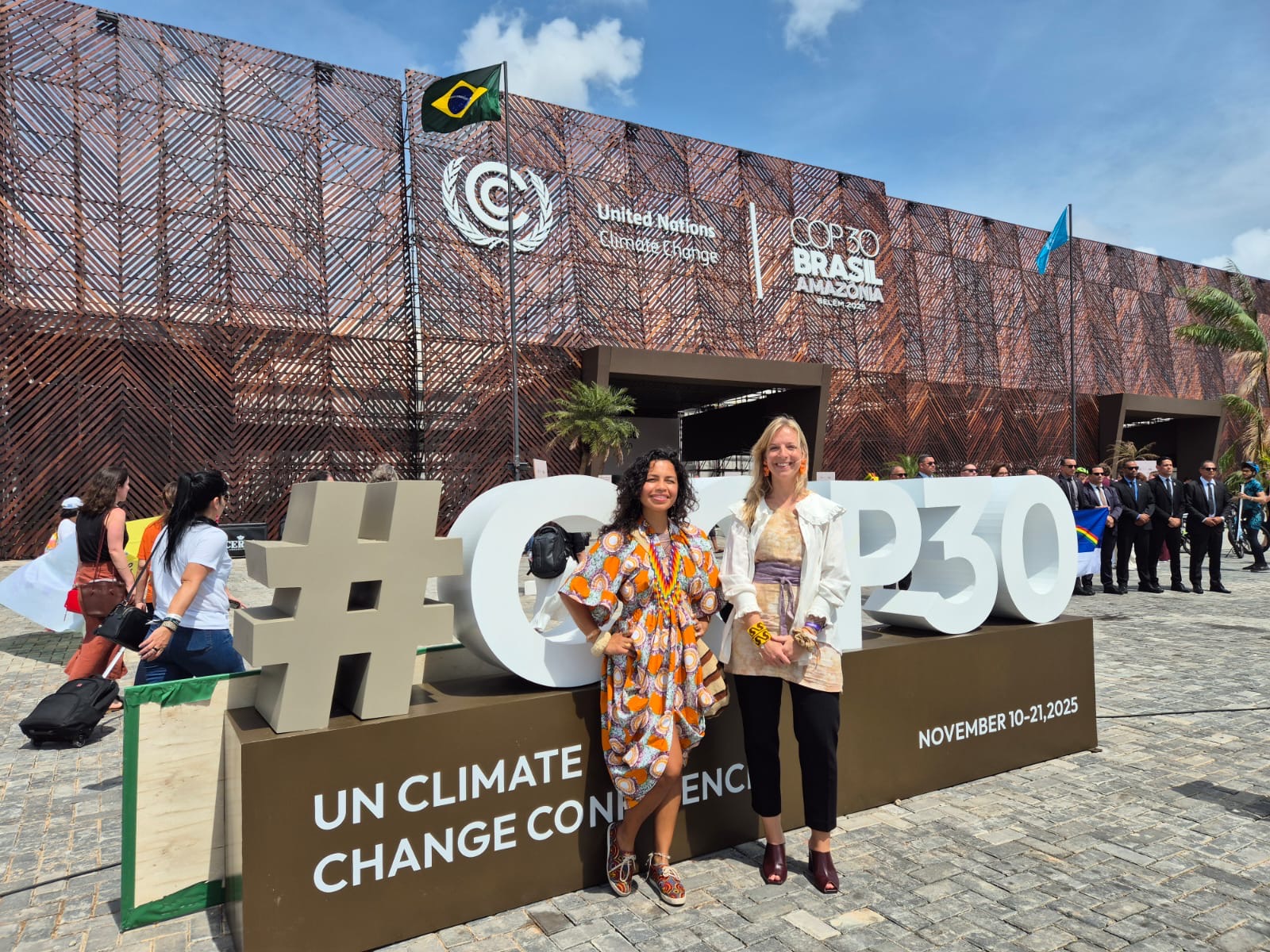 Two people in front of the COP30 sign in Belem, Brazil